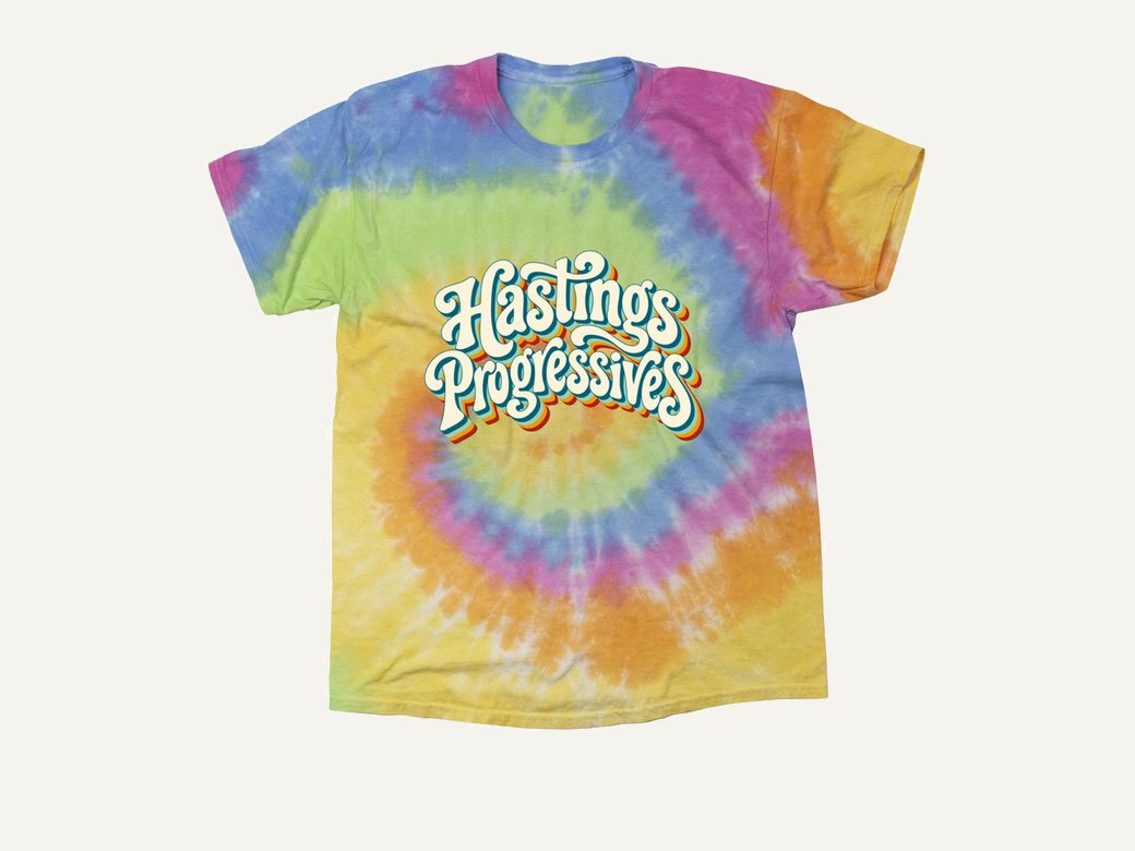 Hastings Progressives retro script logo on a rainbow spiral tie-dye tee.